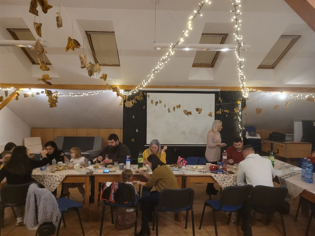 People gathered around a table at Church at the Table in southern Slovakia, sharing a meal together