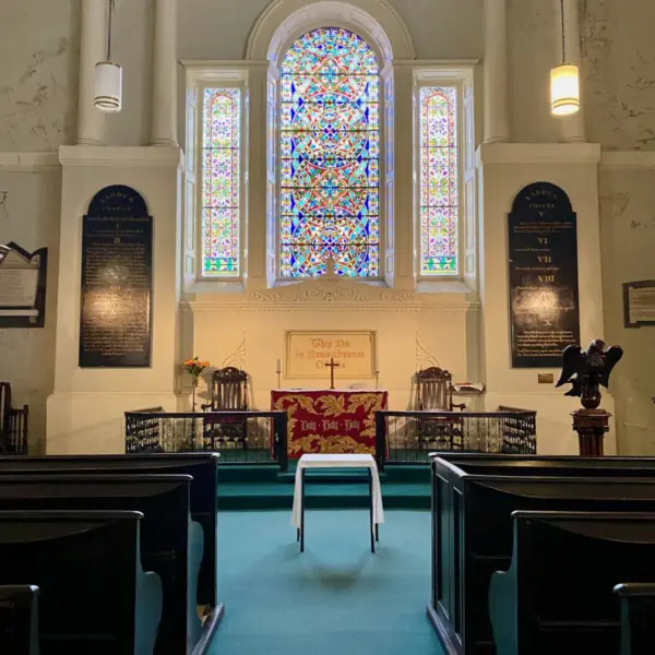 Interior of a church in Ireland with pews, stained glass, and a communion table