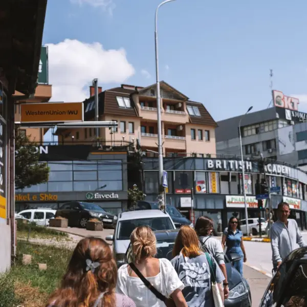 Pedestrians walking along a busy commercial street in Kosovo