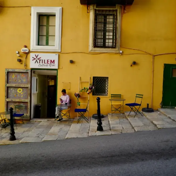 Small sidewalk café outside a colorful building on a street in Malta