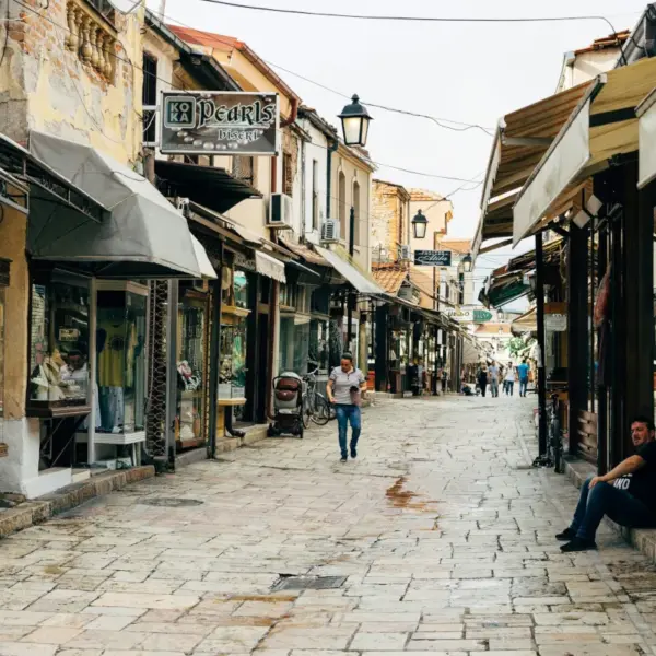 Historic cobblestone market street in North Macedonia lined with small shops and traditional buildings