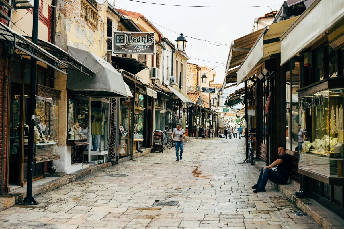 Historic cobblestone market street in North Macedonia lined with small shops and traditional buildings
