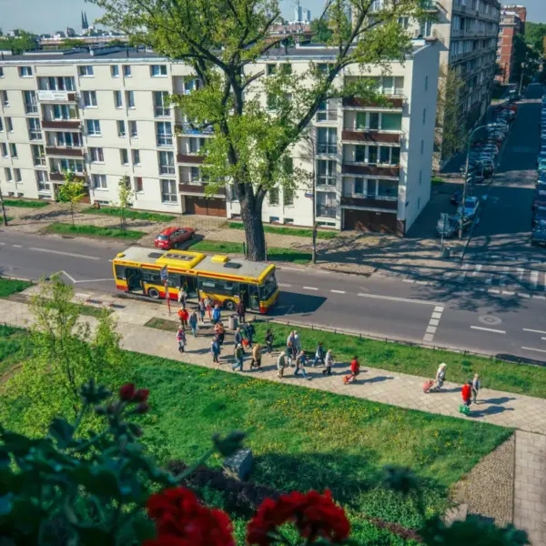 People waiting at a bus stop on a residential street in Poland