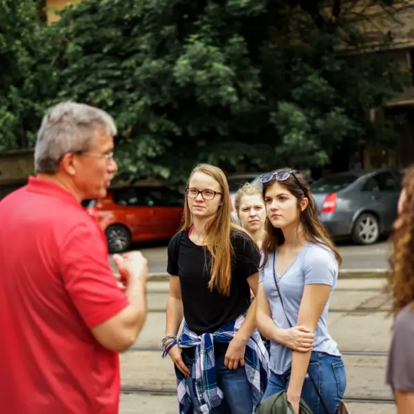 Man speaking with a small group outdoors in Romania