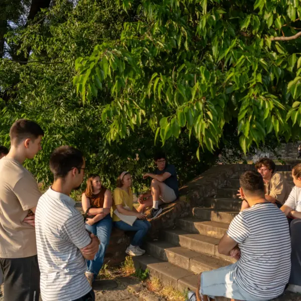 Small group gathered outdoors beneath trees in Serbia for conversation and fellowship