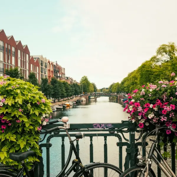 Flower-lined canal in the Netherlands with bicycles parked along the railing
